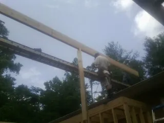 Carpenter setting a ridge beam over a new addition frame — Ice Dam Removal by Roofing Brothers in Stockett