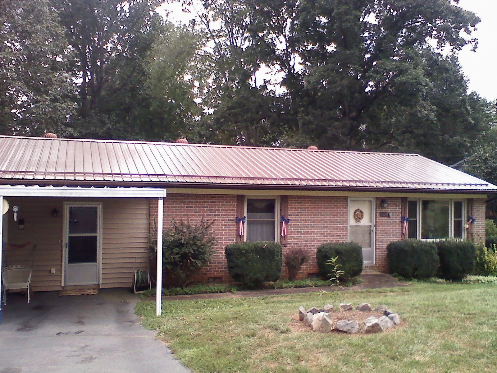 Bronze metal roof and carport on a brick ranch home — Roof Repair work by our crew in Stockett
